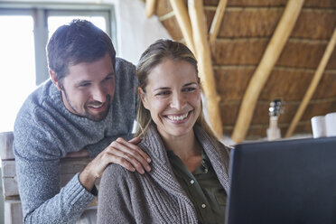 Smiling couple using laptop - HOXF02235