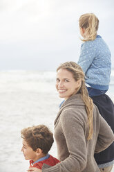 Porträt lächelnd Familie zu Fuß auf Winter Strand - HOXF02243