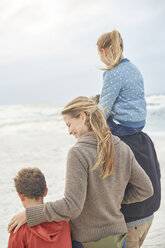 Family walking on winter beach - HOXF02250