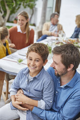 Portrait smiling father and son enjoying patio lunch - HOXF02254