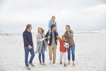 Multi-generation family walking on winter beach - HOXF02257