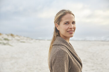 Portrait smiling blonde woman on winter beach - HOXF02265