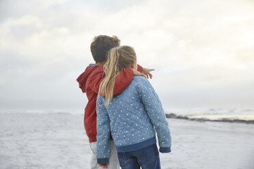 Affectionate brother and sister looking at winter ocean - HOXF02267