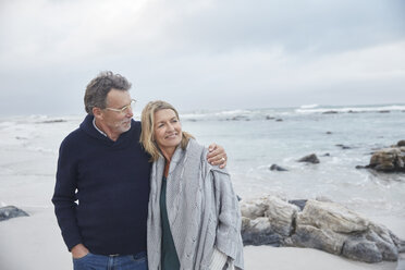 Affectionate couple hugging on winter beach - HOXF02273