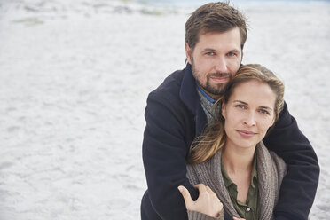 Porträt heiteres zärtliches Paar, das sich am Strand umarmt - HOXF02275
