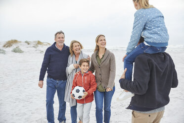 Mehrgenerationenfamilie mit Fußball am Winterstrand - HOXF02276