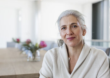 Portrait mature woman sitting at dining table - HOXF02279