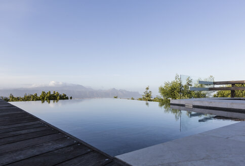 Ruhiger Luxus-Infinity-Pool mit Bergblick unter blauem Himmel - HOXF02371