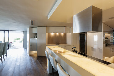 Illuminated, modern, minimalist luxury home showcase interior kitchen - HOXF02396