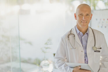 Portrait confident male doctor with digital tablet - HOXF02420