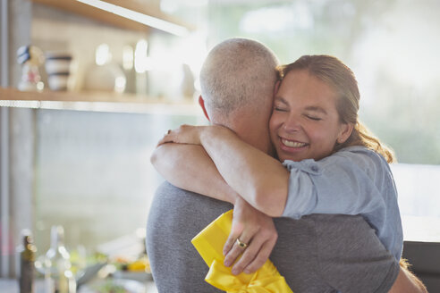 Glückliches Paar, das sich in der Küche umarmt - HOXF02422