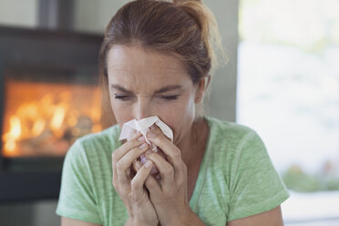 Woman with tissue blowing nose - HOXF02430