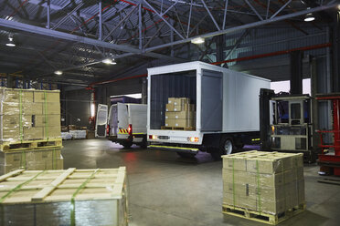 Trucks and cardboard box pallets at distribution warehouse loading dock - HOXF02453
