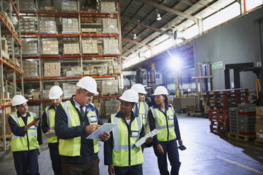 Manager and workers talking in distribution warehouse - HOXF02465
