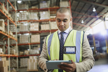 Manager using digital tablet in distribution warehouse - HOXF02471