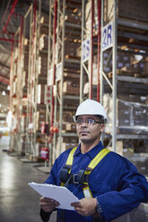 Serious worker with clipboard in distribution warehouse - HOXF02473