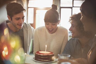 Young adult friends celebrating birthday with cake and candle - HOXF02478