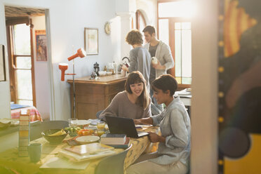 Junge Studentinnen studieren am Laptop am Küchentisch - HOXF02507