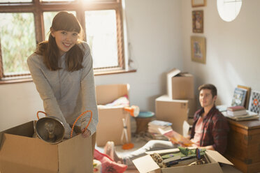 Portrait lächelndes junges Paar beim Auspacken von Umzugskartons in einer Wohnung - HOXF02526