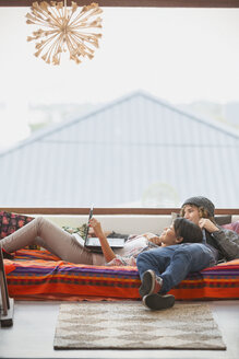 Junges Paar entspannt mit Laptop am Fenster - HOXF02534