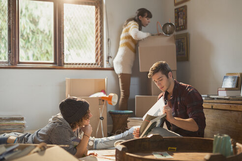 Junge Erwachsene Freunde Mitbewohner packen Kisten aus und lernen in der neuen Wohnung - HOXF02575