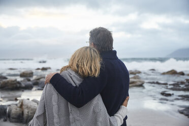 Serene couple hugging on winter beach - HOXF02594