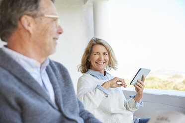 Älteres Paar benutzt digitales Tablet auf der Terrasse - HOXF02596
