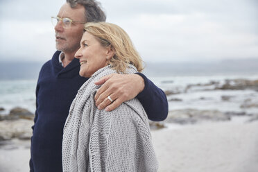 Affectionate senior couple hugging on winter beach - HOXF02601