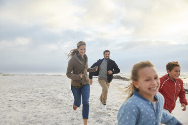 Verspielte Familie beim Laufen am Strand - HOXF02608