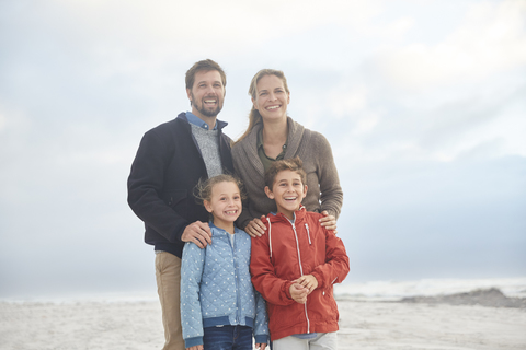Porträt lächelnde Familie am Winterstrand, lizenzfreies Stockfoto