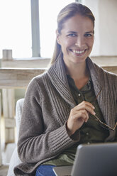 Portrait smiling woman using laptop - HOXF02620