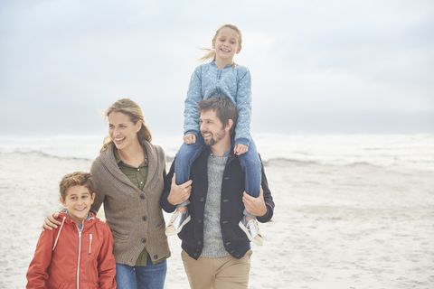 Familienspaziergang am Winterstrand, lizenzfreies Stockfoto