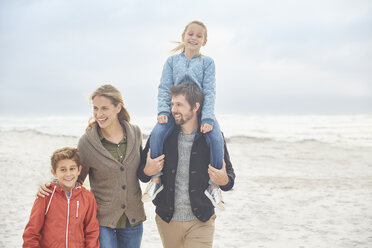 Family walking on winter beach - HOXF02633