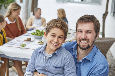 Porträt begeisterter Vater und Sohn beim Mittagessen im Innenhof - HOXF02644