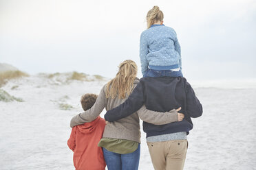 Liebevolle Familie beim Spaziergang am Winterstrand - HOXF02652