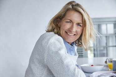 Porträt lächelnde ältere Frau beim Frühstück auf der Terrasse - HOXF02662
