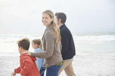 Porträt lächelnd Familie zu Fuß auf Winter Strand - HOXF02666