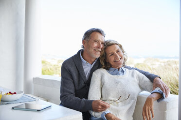 Lächelndes älteres Paar entspannt sich auf der Terrasse - HOXF02676