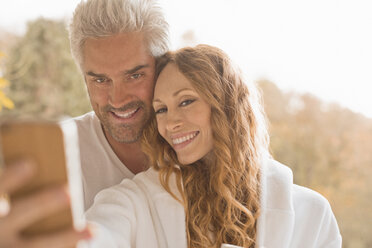 Zärtliches Paar lächelnd unter Selfie mit Kamera-Handy im Freien - HOXF02687