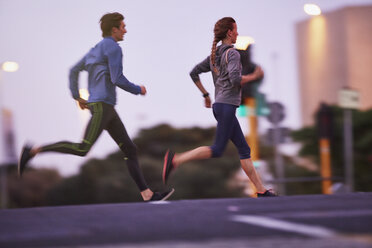 Runner couple running on urban city street - HOXF02763