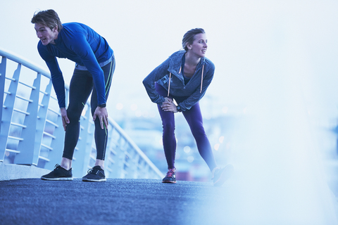 Läuferpaar vertritt sich die Beine auf einem Steg, lizenzfreies Stockfoto