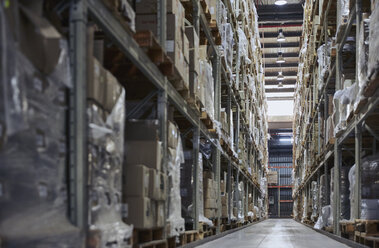 Merchandise cardboard boxes stacked on shelves in distribution warehouse - HOXF02878