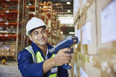 Worker with scanner scanning boxes in distribution warehouse - HOXF02898