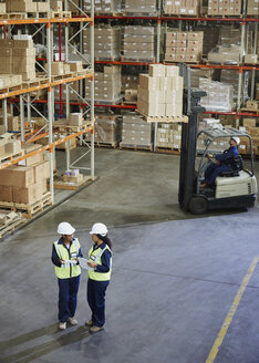 Gabelstapler und Arbeiter treffen sich in einem Vertriebslager - HOXF02906