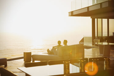 Silhouette Paar entspannt auf Chaiselongue genießen Sonnenuntergang Meerblick - HOXF02919
