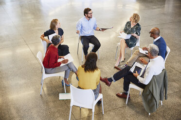 Business people talking in circle meeting - HOXF02973
