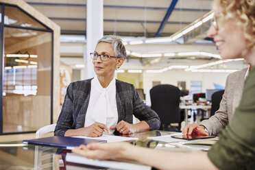 Businesswomen listening in conference room - HOXF02995