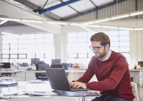 Geschäftsmann arbeitet am Laptop im Büro, lizenzfreies Stockfoto