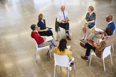 Business people talking in meeting circle - HOXF03004