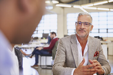 Businessmen talking in meeting - HOXF03043